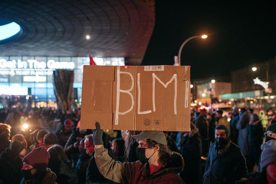 A protester carries a sign reading "BLM" outside the Barclays Center during a demonstration on November 19th criticizing the Kyle Rittenhouse verdict.